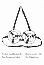 Close-up of silver-tone concentric rings and studded black straps on harness bra