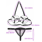 Angled view of black ring harness bra and chain-detail thong worn by model with censor overlays