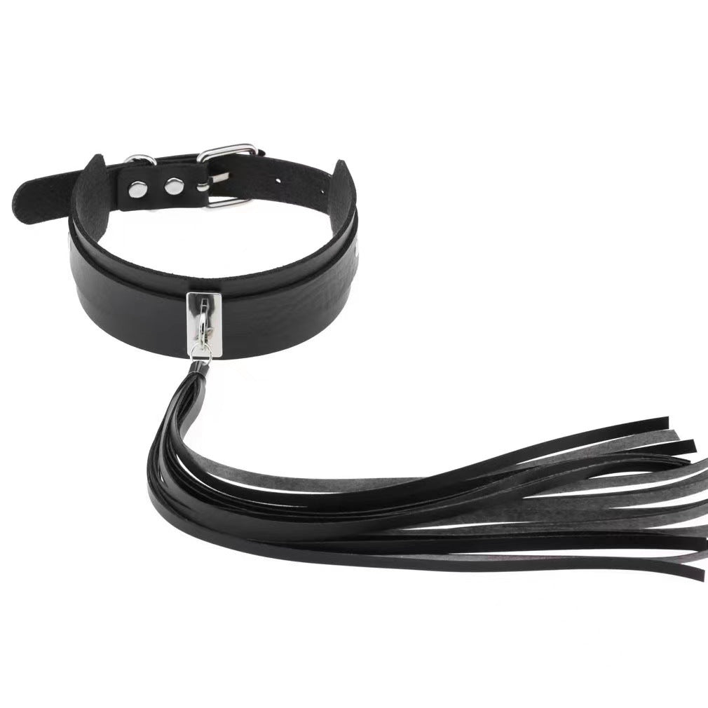 Close-up of black collar with metal front attachment and long tassel worn