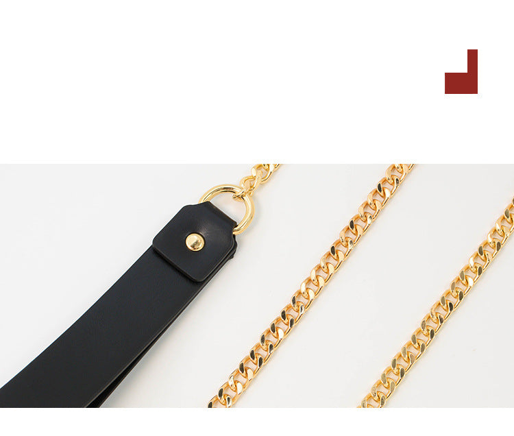 Close-up of black leather strap and polished gold-tone chain hardware